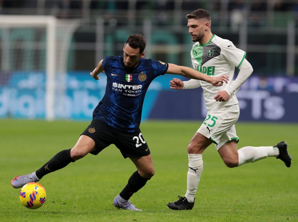 MILAN, ITALY - FEBRUARY 20: Hakan Calhanoglu of FC Internazionale battles for possession with Domenico Berardi of US Sassuolo during the Serie A match between FC Internazionale and US Sassuolo at Stadio Giuseppe Meazza on February 20, 2022 in Milan, Italy. (Photo by Emilio Andreoli - Inter/Inter via Getty Images)