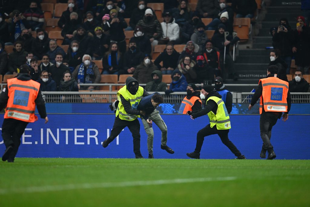 MILAN, ITALY - FEBRUARY 05: A security guard runs towards a pitch invader during the Serie A match between FC Internazionale and AC Milan at Stadio Giuseppe Meazza on February 05, 2022 in Milan, Italy. (Photo by Claudio Villa/AC Milan via Getty Images)