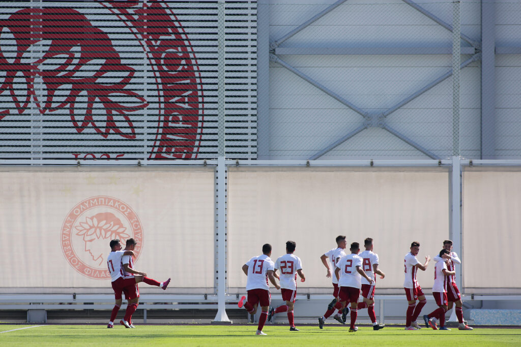 PIRAEUS, GREECE - SEPTEMBER 18: George Fekkas of Olympiacos FC celebrates with team mates after scoring his team's first goal during the UEFA Youth League match between Olympiacos FC and Tottenham Hotspur on September 18, 2019 in Piraeus, Greece. (Photo by Milos Bicanski/Getty Images)